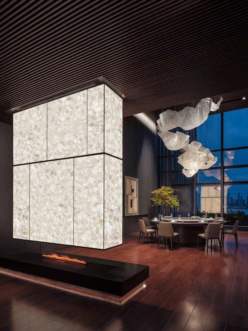 Volume architectural en quartz blanc rétroéclairé près d’un foyer