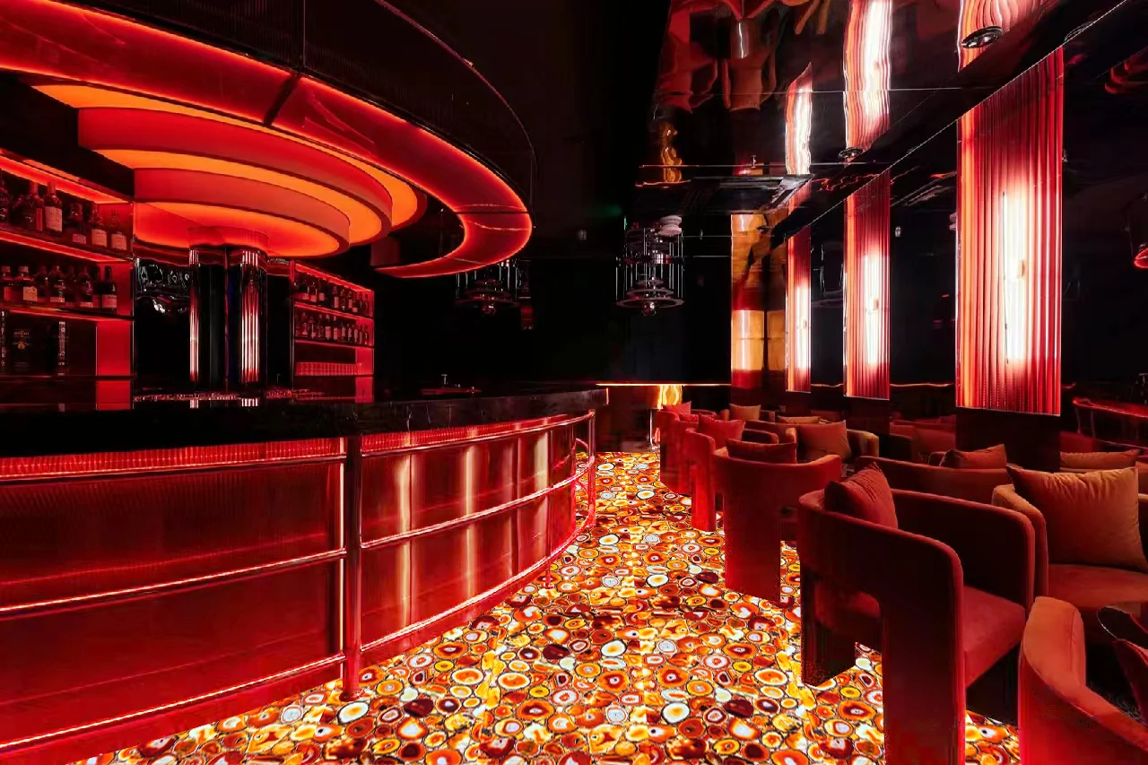 Bar rouge aux courbes lumineuses et sol en agate rétroéclairée