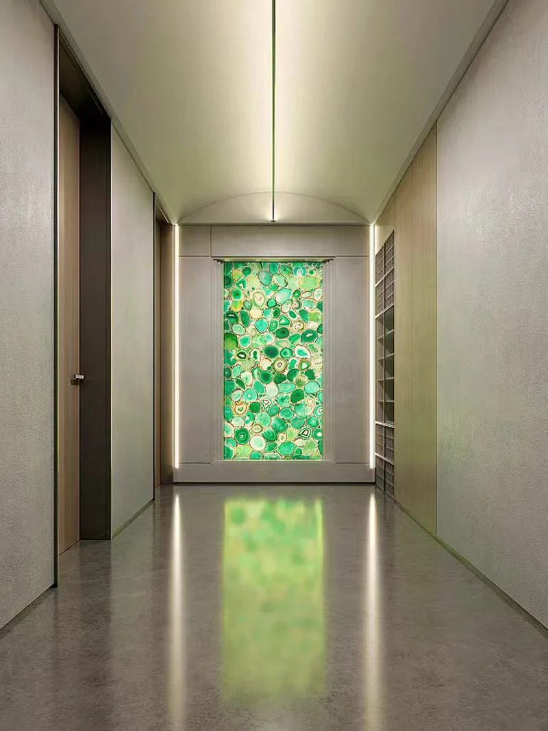 Panneau architectural en agate verte rétroéclairée au bout d’un corridor