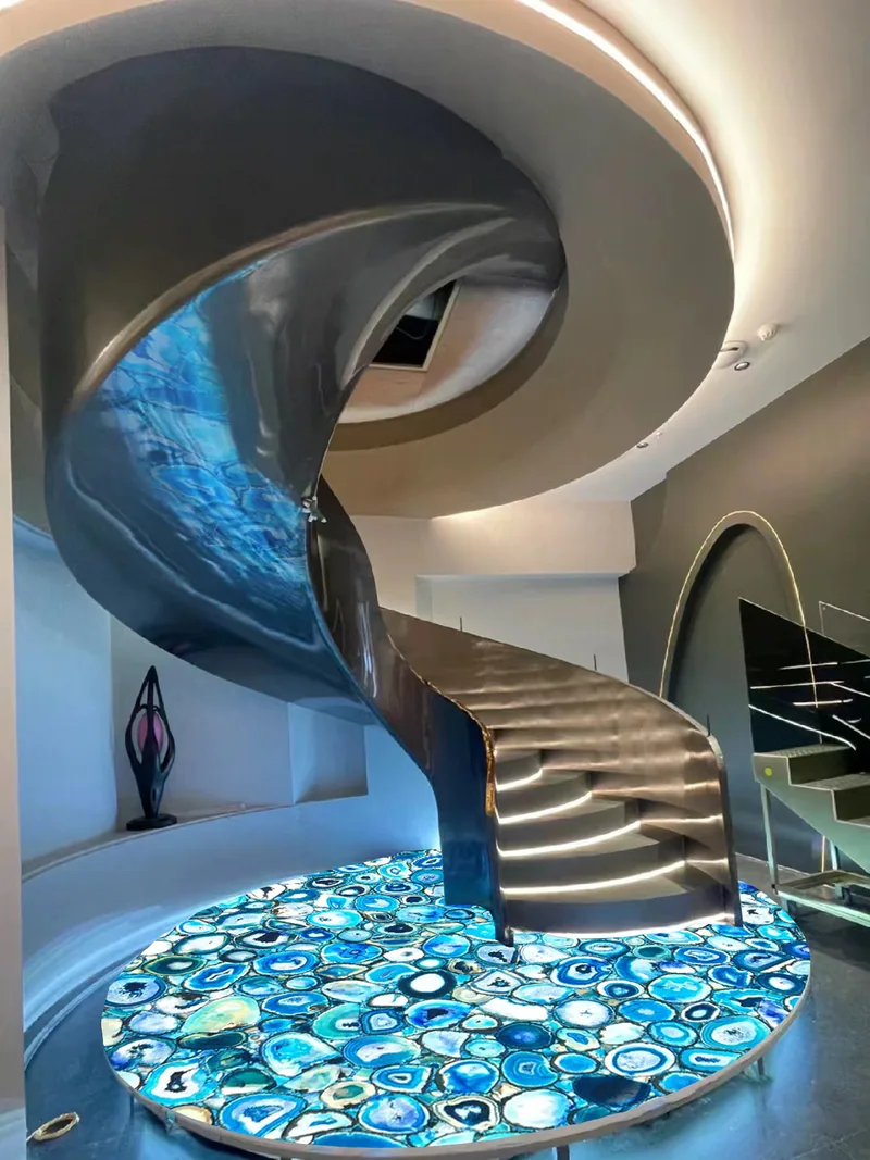 Sol circulaire en agate bleue au pied d’un escalier sculptural